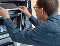 Appliance repair technician replacing a microwave vent filter in Little Rock, AR