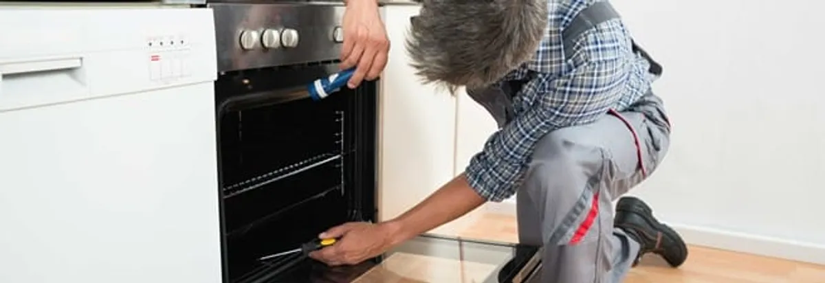 Oven repair technician inspecting and servicing an electric oven in Little Rock, AR